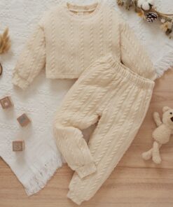 A soft, khaki cable knit loungewear set for babies and toddlers, including a long-sleeved jumper and matching joggers, laid flat on a white blanket with wooden toys.