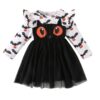 A long-sleeved girls' Halloween dress featuring a white top with a bat and pumpkin print, and a black main dress with a large cat face and a tulle skirt.