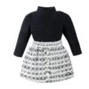 A chic two-piece girls' outfit, featuring a long-sleeved black ribbed polo neck top and a matching black and white tweed skirt with pearl buttons.