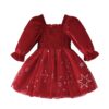 A little girl's festive Christmas dress in festive red, featuring a smocked bodice, long puff sleeves, and a tulle skirt with a white star and snowflake print.