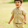 A smart unisex children's two-piece summer outfit in a khaki linen-blend, featuring a short-sleeved collared shirt with pockets and matching shorts with an elasticated waist.