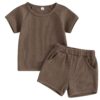 A unisex baby and toddler waffle-knit loungewear set in a rich coffee brown colour, including a short-sleeved top and matching shorts with pockets.