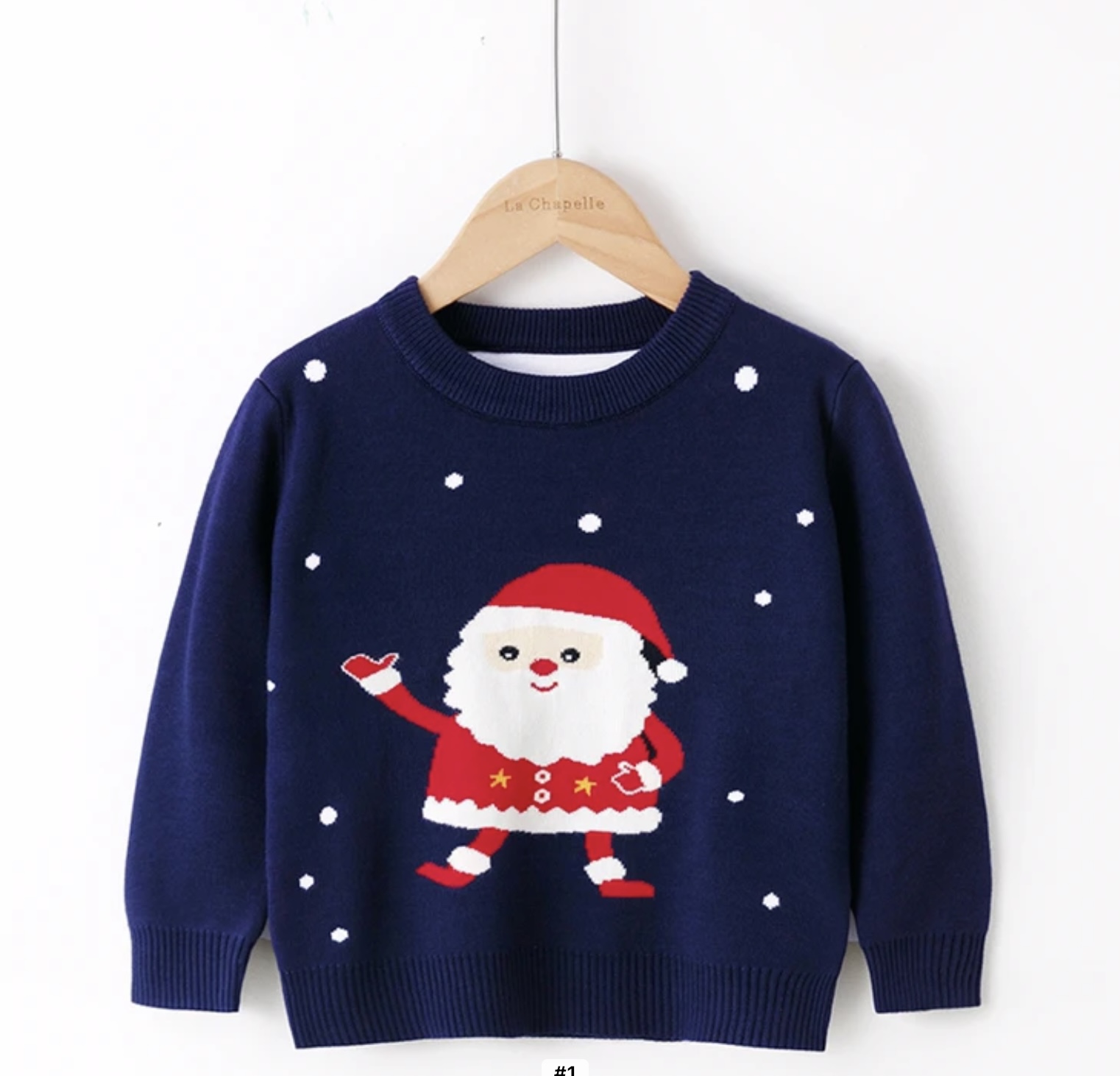 A soft, navy blue knitted children's Christmas jumper featuring a large, cheerful cartoon Santa Claus with a white beard and red suit, surrounded by white knitted snow dots.