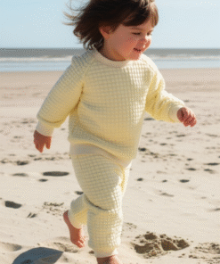 A unisex children's loungewear set in a soft, buttermilk yellow quilted fabric, including a long-sleeved top and matching jogger trousers.