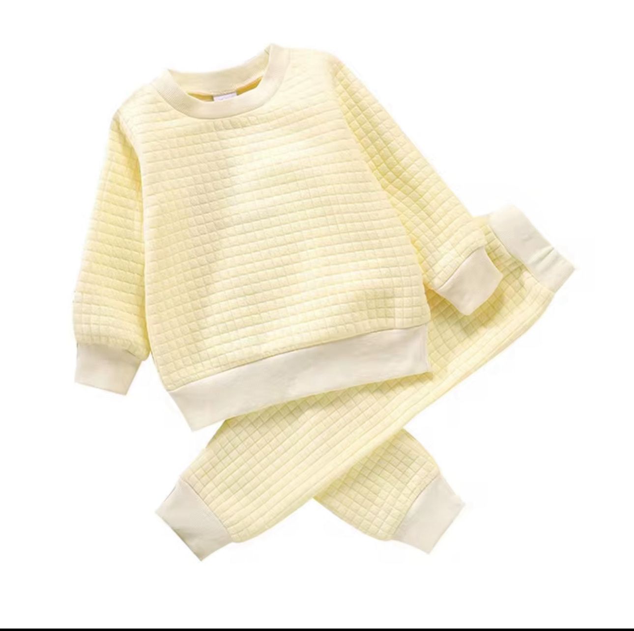 A unisex children's loungewear set in a soft, buttermilk yellow quilted fabric, including a long-sleeved top and matching jogger trousers.